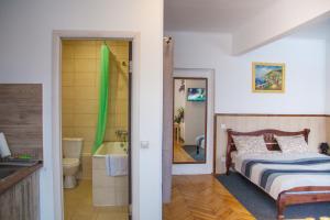 捷尔诺波尔ART ApartmenT的一间卧室配有一张床,浴室设有浴缸