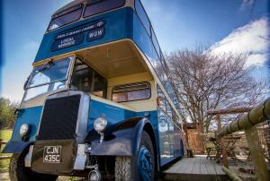 兰达西尔Ceridwen Glamping, double decker bus and Yurts的停在院子的蓝色双层公车