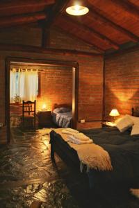 埃尔奥约Criollo Lodge的一间卧室设有两张床和砖墙