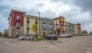 达文波特My Place Hotel-Davenport/Quad Cities, IA的停车场内有车辆的旅馆