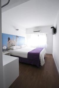 布宜诺斯艾利斯因菲尼托酒店的一间卧室设有一张大床和一个窗户。