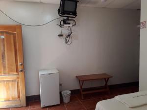 比亚米尔港Hospedaje Mother Fanny的一间墙上配有电视和一张桌子的房间