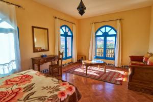 AoufousMaison D'hotes Sahara的卧室配有一张床、一张书桌和窗户。