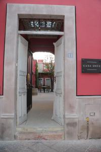 克雷塔罗Hotel Casa Once的通往红色墙的建筑物的敞开的门