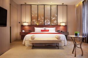 上海上海衡山路十二号华邑酒店的一间卧室配有一张大床和电视