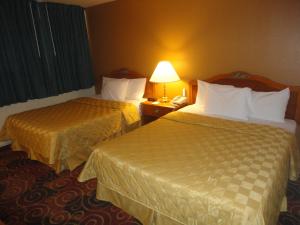 圣罗莎Americas Best Value Inn Santa Rosa, New Mexico的配有2张床位的酒店客房,配有灯和电话