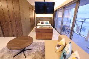 那霸Tabinoteitaku Okinawa Naha的客房设有1张床、1张桌子和1台电视。