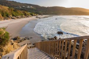 拉科鲁尼亚Hotel Santa Catalina by Bossh Hotels的木制阳台享有海滩美景。