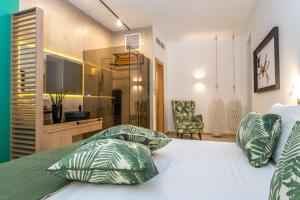 卡拉马基Kalamaki Luxury Suites的一间卧室配有带绿色和白色枕头的床