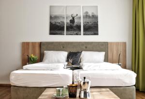 米明Seelos - Alpine Easy Stay - Bed & Breakfast的两张带白色床单的床和墙上的鹿画
