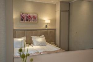 斯塔佐扎格斯基巴尼Spa Hotel Armira的一间卧室配有一张带白色枕头和镜子的床