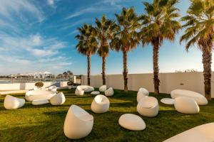 蒙蒂戈杜杜纳马尔公寓式酒店的公园设有白色椅子和棕榈树