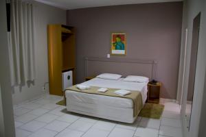帕苏斯总统酒店的一间卧室配有一张床,上面有两条毛巾