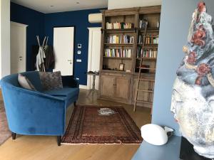 拉文纳Abitare al 42的蓝色的客厅,配有蓝色椅子和书架