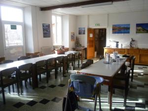 若西耶Maison familiale des Gueyniers的用餐室设有桌椅和窗户。