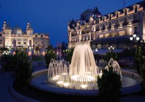 博索莱伊Chambre Love Luxe Monaco的夜间在建筑物前的喷泉