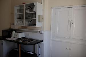 赫克瑟姆Newbrough Bunkhouse的厨房配有炉灶和白色橱柜。