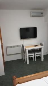 查普利纳杰奇汽车旅馆的白色的客房设有桌子和墙上的电视