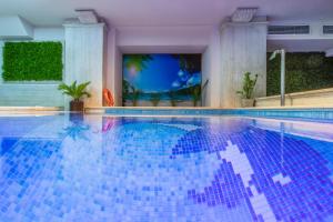 塞萨洛尼基Egnatia Palace Hotel & Spa的水面上蓝色瓷砖的游泳池