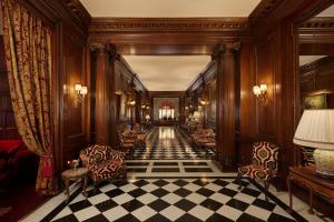 巴黎拉斐尔酒店的走廊上设有椅子和 ⁇ 格地板
