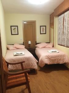 GalendeCasa Sanabresa的一间卧室配有两张床、粉色床单和椅子