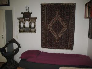 哥本哈根艾斯本尤尔斯民宿的卧室配有一张床,墙上挂着地毯
