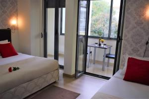 里斯本尤尼维索罗曼蒂克旅馆的一间卧室设有两张床、一张桌子和一个窗口