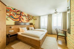 安贝格布鲁纳酒店的卧室配有一张床,墙上挂有绘画作品