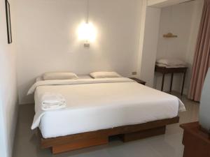 春蓬帕拉多恩旅馆的卧室配有一张白色大床