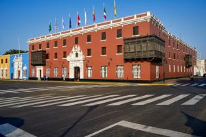 特鲁希略Costa del Sol Trujillo Centro的一座红色的大建筑,上面有旗帜