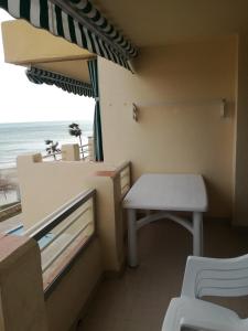 圣卡洛斯拉腊皮塔Atico primer linea de mar con piscina en EbreHogar的阳台配有桌子、椅子和雨伞。