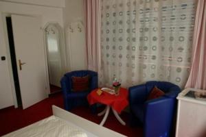 Vielbrunn米歇尔施塔特酒店的一间卧室配有2把蓝色椅子和红色桌子