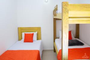 杰里科Hotel Madre Laura Jericó的橙色和白色的客房内的两张双层床