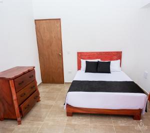 杰里科Hotel Madre Laura Jericó的一间卧室配有一张床和一个木制梳妆台