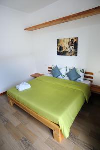 邦劳罗望子度假酒店的一间卧室配有带蓝色枕头的大型绿床