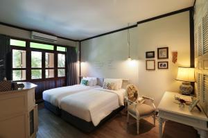 曼谷曼谷拉威坎拉亚酒店的一间卧室配有一张床、一把椅子和一张书桌