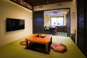 京都京之宿月光庵的客厅配有桌子和电视