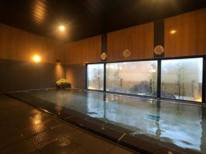 土浦市Hotel Route-Inn Tsuchiura的一座带大窗户的建筑中的游泳池