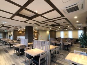 土浦市Hotel Route-Inn Tsuchiura的用餐室配有木桌和椅子