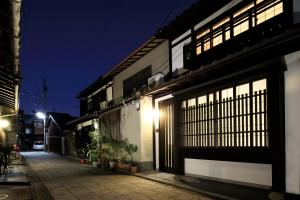 京都京之宿月光庵的街上的一座建筑,晚上有明亮的窗户