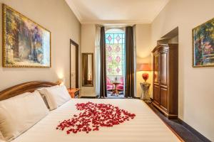 罗马罗马花园酒店的一间卧室,床上有一堆玫瑰花瓣
