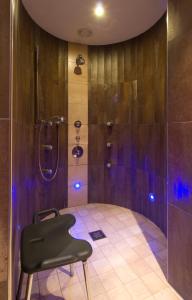 蒂罗尔-基希贝格布瑞特酒店的浴室内配有带黑椅的淋浴