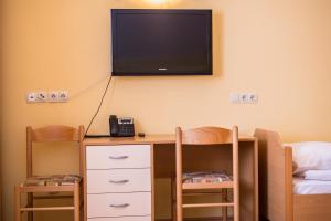 Starše贝诺宾馆的一间设有一张桌子的房间,墙上配有电视