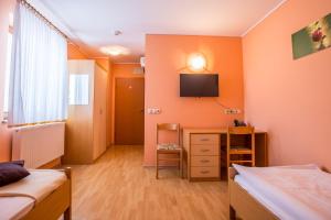 Starše贝诺宾馆的一间卧室设有两张床,墙上配有电视。