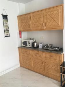 南芭堤雅塔莱1B景观公寓的厨房配有木制橱柜和台面