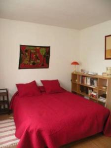 卢维耶路德斯富热尔斯尚布里住宿加早餐旅馆的一间卧室设有红色的床和书架