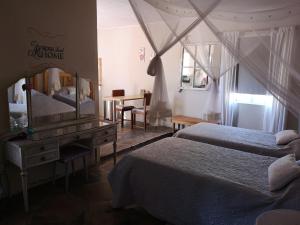 库斯Terra Rouge Guestfarm & Sonstraal Farmhouse的一间卧室配有两张床、镜子和一张书桌