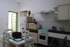 瓜鲁柳斯Hostel 33 Brazil的厨房配有白色冰箱、桌子和椅子
