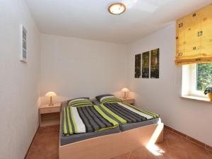 克吕茨Farm holiday home in Damshagen with garden seating and sauna的一间卧室配有床和2个床头柜