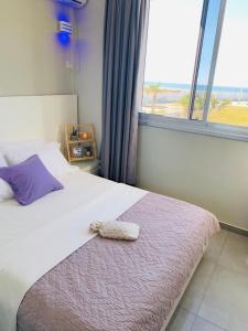 巴特亚姆Motel Hofim的一间卧室配有一张带枕头和窗户的床